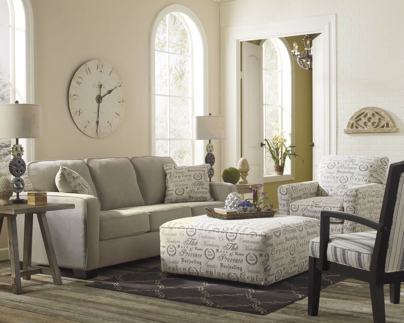 Light toned living room stands over grey hardwood flooring, with neutral  grey sofa next to