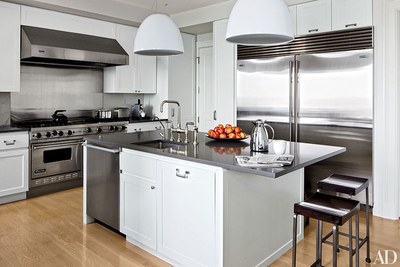 Domed pendant lights by Artemide hang above a Caesarstonetopped island in a  Milwaukee highrise apartments kitchen