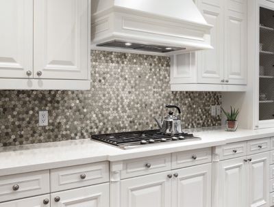 Kitchen with a honeycomb mosaic tile backsplash in a variety of shades.