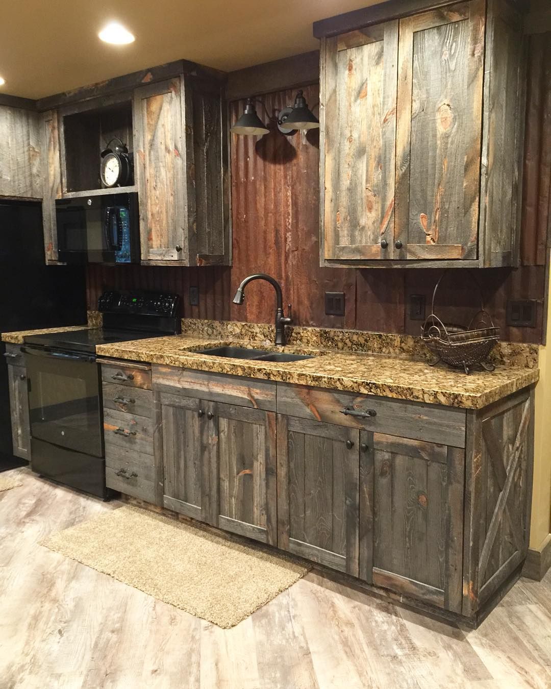 A little barnwood kitchen cabinets and corrugated steel backsplash. Love  how rustic and homey it is! #cabininthewoods.