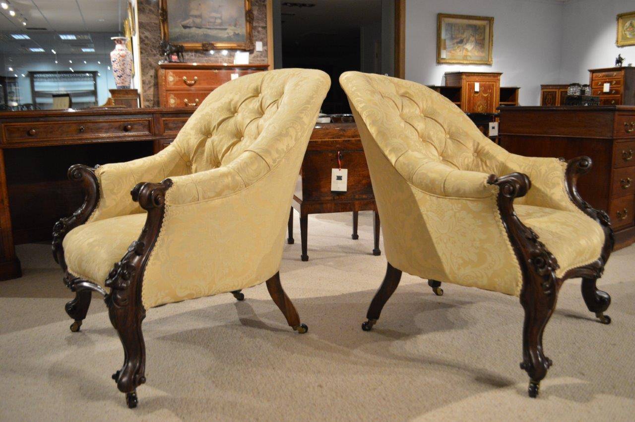 Pair of carved solid rosewood Victorian Period deep buttoned antique  armchairs. Each with a beautiful