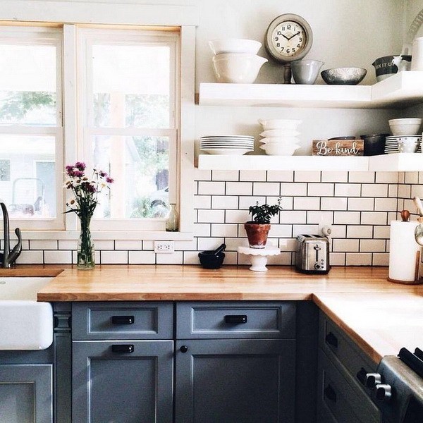 White-tiled walls and backsplash with gray grout give more warmth to this  farmhouse kitchen