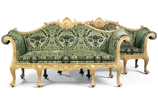 The sofas feature serpentine padded back, outscrolled arms and serpentine  seat covered in green floral