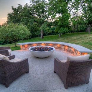 Large transitional backyard stamped concrete patio photo in Cedar Rapids  with a fire pit and a