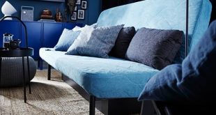 A light blue NYHAMN sofa bed with blue accent cushions