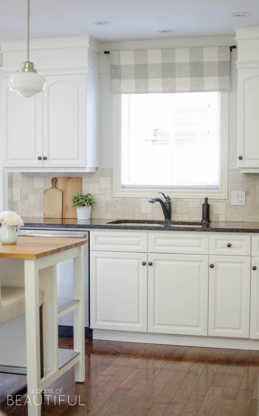 A window valance made from neutral buffalo check fabric compliments this  simple farmhouse kitchen perfectly.