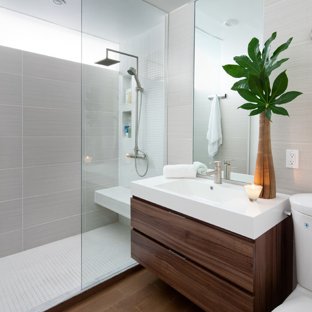 Example of a minimalist gray tile bathroom design in Toronto with an  integrated sink, flat
