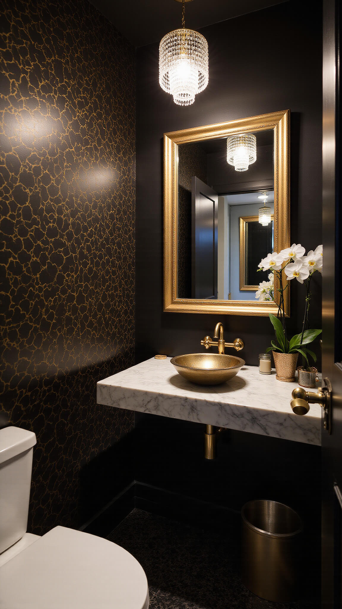 Elegant 5'x7' urban powder room featuring black and gold geometric wallpaper, crystal pendant lighting, marble floating vanity with brass fixtures, and a gilt-framed mirror.