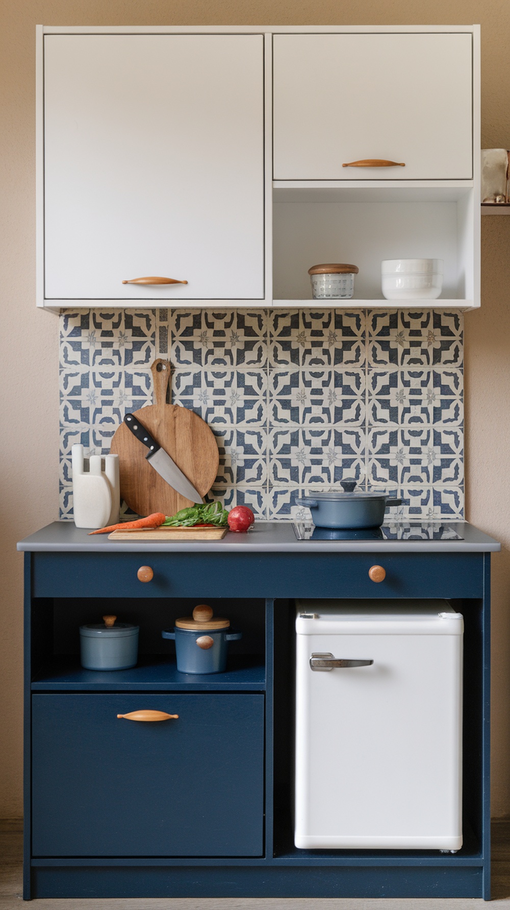 A compact kitchen with navy cabinets, patterned backsplash, and a small fridge, showcasing bold colors and efficient design.